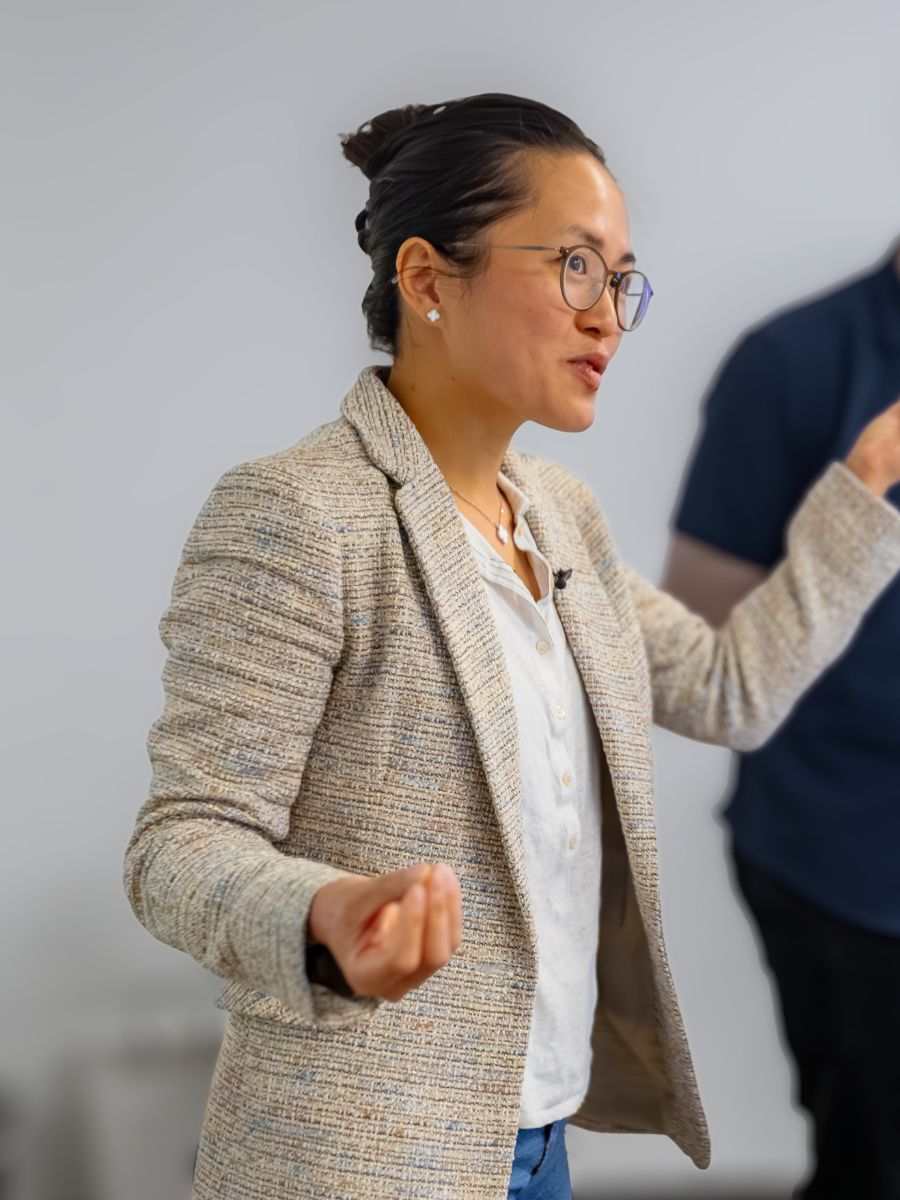 Integrante del equipo de Orbiss con chaqueta de tweed, hablando durante un taller de equipo