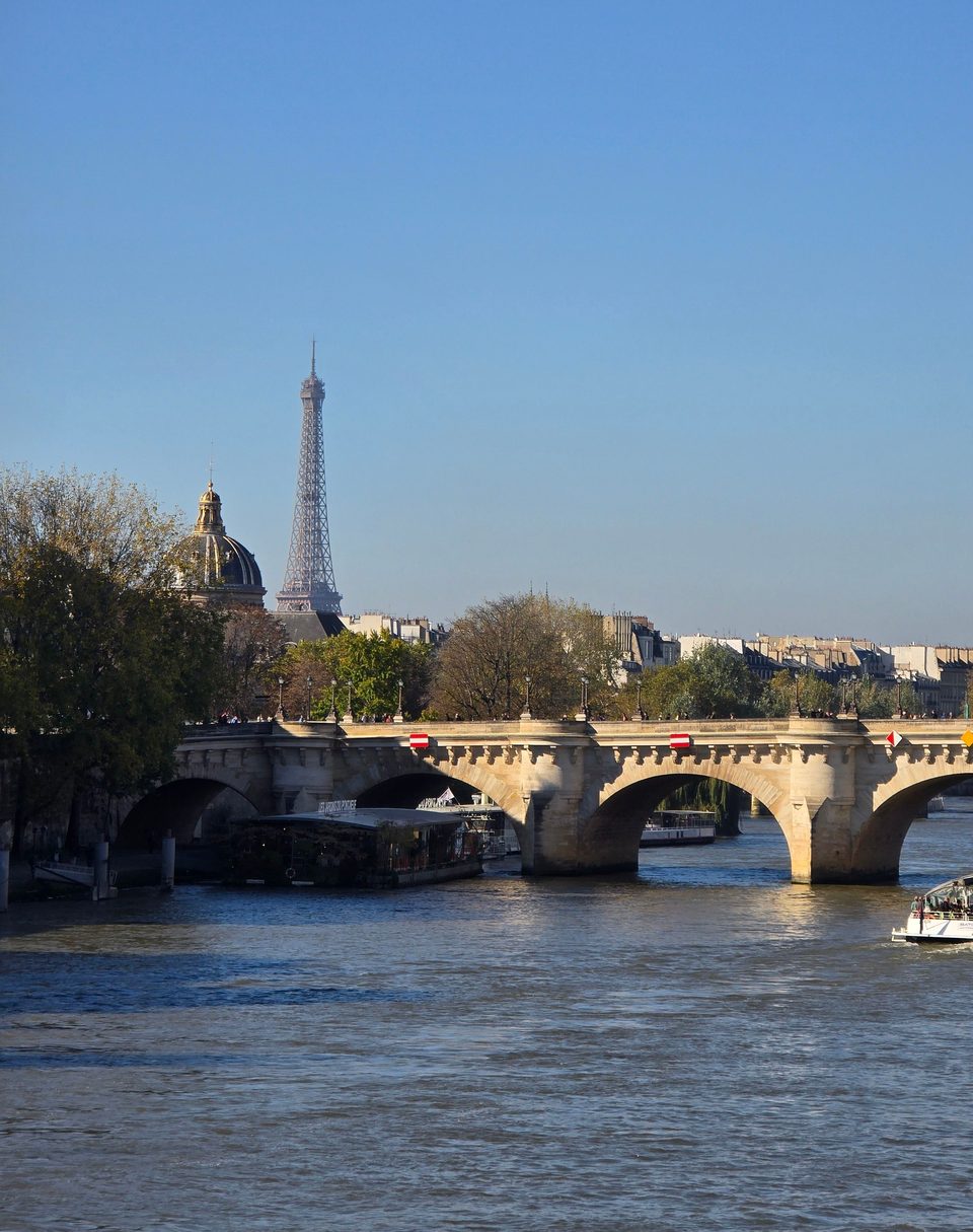 The Eiffel Tower beyond a stone bridge over the Seine in Paris