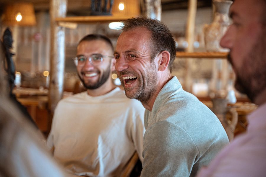 Colegas riendo juntos alrededor de una mesa de restaurante