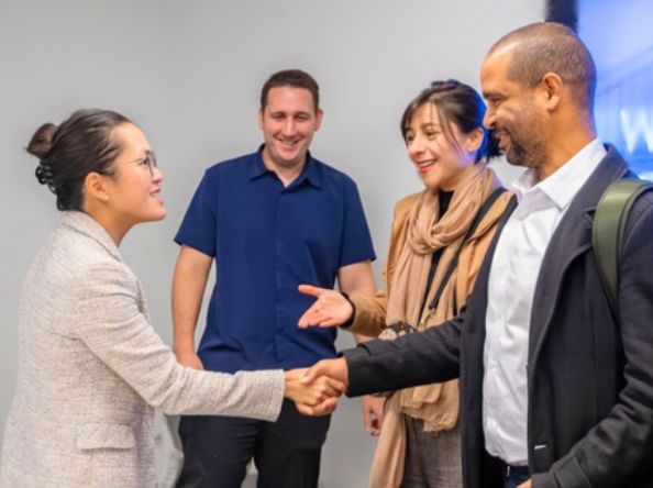 Profesionales sonriendo y estrechándose la mano en un evento de networking