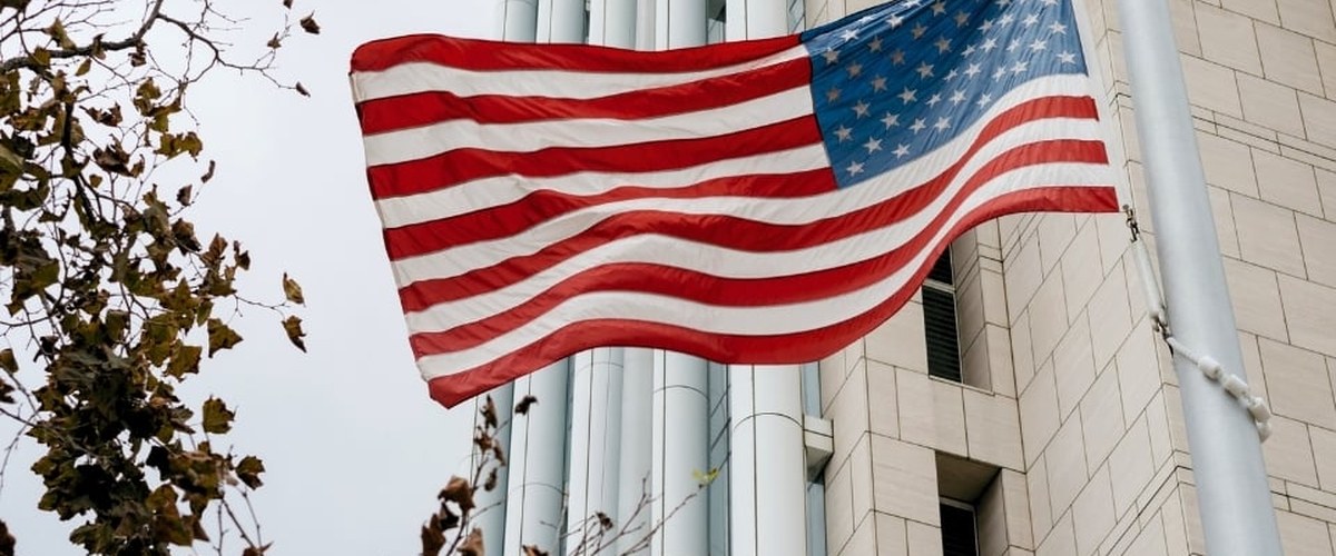 Drapeau américain flottant devant un immeuble de bureaux en pierre